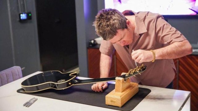 Noel Gallagher puts the finishing touches to one of his new custom guitars